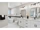 Bathroom featuring double sink, granite countertops, and a modern soaking tub at 2321 S Galapago St, Denver, CO 80223