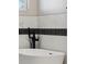 Modern bathroom featuring a white soaking tub with matte black fixtures and marble-look tile at 2321 S Galapago St, Denver, CO 80223