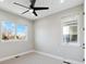 Sunlit bedroom features neutral walls, carpet, ceiling fan, and two windows at 2321 S Galapago St, Denver, CO 80223