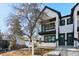 Modern townhome showcasing black-framed windows, black trim, and a welcoming front yard at 2321 S Galapago St, Denver, CO 80223