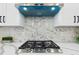 Modern kitchen with stainless steel range and hood with marble backsplash at 2321 S Galapago St, Denver, CO 80223