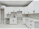 Basement kitchenette with white shaker cabinets, marble countertops, and modern fixtures at 2321 S Galapago St, Denver, CO 80223