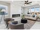 Sunlit living room featuring a modern fireplace, plush seating, and a stylish ceiling fan at 2321 S Galapago St, Denver, CO 80223