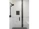 Sleek shower featuring black fixtures, marble-look tile, and a dark-tiled shower floor at 2321 S Galapago St, Denver, CO 80223