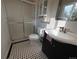 Cozy bathroom featuring a glass shower door, cabinet, and stylish black and white patterned tile flooring at 5163 E 123Rd Ct, Thornton, CO 80241