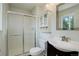Well-lit bathroom with glass-enclosed shower, vanity with storage, and black and white tile at 5163 E 123Rd Ct, Thornton, CO 80241
