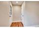 Hallway with white walls, wood-look floors, and closet doors at 7110 S Gaylord St # L7, Centennial, CO 80122