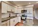 Close-up of renovated kitchen with granite counters, white cabinets, and stainless steel appliances at 7110 S Gaylord St # L7, Centennial, CO 80122
