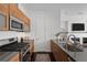 Modern kitchen featuring wood cabinets, stainless steel appliances, and dark countertops at 3131 Vallejo St, Denver, CO 80211