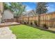 Backyard with a well-maintained lawn, wooden fence, a wooden patio and white stone walkway at 17499 E Whitaker Dr, Aurora, CO 80015