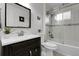 Bathroom with white tile, modern vanity, and a glass-enclosed bathtub with shower at 17499 E Whitaker Dr, Aurora, CO 80015