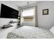Bright bedroom featuring a large TV, open shelving, and a cozy bed with natural light at 17499 E Whitaker Dr, Aurora, CO 80015