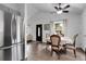 Dining room features a table set for four, hardwood floors, and large windows at 17499 E Whitaker Dr, Aurora, CO 80015
