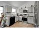 Bright kitchen with stainless steel appliances, a black dishwasher, and wood floors at 17499 E Whitaker Dr, Aurora, CO 80015
