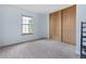 Bright bedroom features soft carpet, fresh paint, and a large window with ample sunlight at 1035 Milo Cir # B, Lafayette, CO 80026