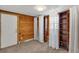 Bedroom with wood paneled walls, carpeted floors, and wooden shelving at 4079 S Bannock St, Englewood, CO 80110
