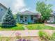 Charming home featuring blue paint, a green lawn, and blooming flowers at 4079 S Bannock St, Englewood, CO 80110