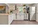Bright kitchen boasts white cabinets, farmhouse sink, stainless appliances, and open shelving at 4079 S Bannock St, Englewood, CO 80110