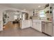 Open kitchen with white cabinets, breakfast bar, stainless appliances, and access to living spaces at 4079 S Bannock St, Englewood, CO 80110