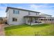 Backyard featuring a well-maintained lawn, covered patio with outdoor seating, and neutral-colored siding at 14391 Shasta Daisy Pt, Parker, CO 80134