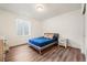 Comfortable bedroom with a blue bed, wood floors, and plenty of natural light at 14391 Shasta Daisy Pt, Parker, CO 80134