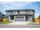 Beautiful two story home with gray siding, a stone facade, three car garage and modern architectural design at 14391 Shasta Daisy Pt, Parker, CO 80134
