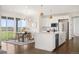 Modern kitchen with white cabinets, stainless steel appliances, a large island, and a view of the backyard at 14391 Shasta Daisy Pt, Parker, CO 80134