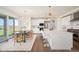 Bright, modern kitchen with stainless steel appliances, white cabinetry, large island and adjacent dining area at 14391 Shasta Daisy Pt, Parker, CO 80134