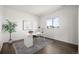 Bright home office with white desk, stylish rug, and large window for ample natural light at 14391 Shasta Daisy Pt, Parker, CO 80134