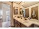 Bathroom featuring vanity with a large mirror and a door to the other parts of the house at 18890 E Carmel Cir, Aurora, CO 80011