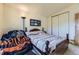 Comfortable bedroom showcasing a decorative wooden bed frame and closet with sliding doors at 18890 E Carmel Cir, Aurora, CO 80011