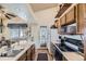 Functional kitchen featuring wood cabinets, a sink, and appliances including a stove and microwave at 18890 E Carmel Cir, Aurora, CO 80011