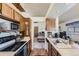 Functional kitchen featuring wood cabinets, a sink, and appliances including a stove and microwave at 18890 E Carmel Cir, Aurora, CO 80011