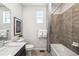 Clean bathroom with white counter tops, dark vanity, tile shower and floors, and modern fixtures at 3379 N Denali St, Aurora, CO 80019