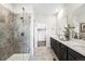 Bright bathroom with a glass enclosed shower, double vanity, and dark cabinets at 3379 N Denali St, Aurora, CO 80019