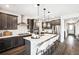 Open kitchen with stainless steel appliances, island with bar stools, and hardwood floors at 3379 N Denali St, Aurora, CO 80019