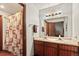 Bathroom with double vanity, large mirror, and a shower with patterned curtain at 107 N Harris St # 306, Breckenridge, CO 80424