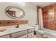 Cozy bathroom featuring a tiled shower, ample counter space, and a decorative oval mirror at 107 N Harris St # 306, Breckenridge, CO 80424