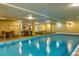 Indoor pool with a hot tub and tables with chairs in a warmly lit recreation room at 107 N Harris St # 306, Breckenridge, CO 80424