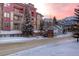 Winter street view of building with snow-covered landscape, mountain view at sunset at 107 N Harris St # 306, Breckenridge, CO 80424