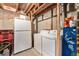 Unfinished basement with exposed ceiling and utilities including washer, dryer, and fridge at 13275 Holly St # B, Thornton, CO 80241