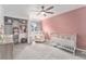 Bright Bedroom features a charming pink accent wall, plush gray carpet, and a ceiling fan at 13275 Holly St # B, Thornton, CO 80241