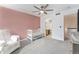 Bright Bedroom features a charming pink accent wall, plush gray carpet, and attached bathroom at 13275 Holly St # B, Thornton, CO 80241