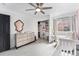 Bright Bedroom features plush gray carpet, built-in closet storage, and a modern ceiling fan at 13275 Holly St # B, Thornton, CO 80241
