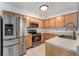 Modern kitchen features stainless steel appliances, wooden cabinets, and recessed lighting at 13275 Holly St # B, Thornton, CO 80241