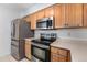 Modern kitchen with stainless steel appliances, wood cabinets, and ample counter space at 13275 Holly St # B, Thornton, CO 80241