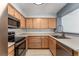 The kitchen offers wood cabinets, tile floors, and black appliances for a modern look at 13275 Holly St # B, Thornton, CO 80241