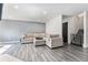 Spacious living room featuring a cozy sectional sofa and gray laminate flooring at 13275 Holly St # B, Thornton, CO 80241