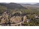 Aerial view of a custom home nestled in a lush forest with views of nearby mountain peaks at 6016 Stone Creek Dr, Evergreen, CO 80439