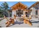 Backyard patio with stone fireplace and wooden Adirondack chairs, perfect for entertaining at 6016 Stone Creek Dr, Evergreen, CO 80439